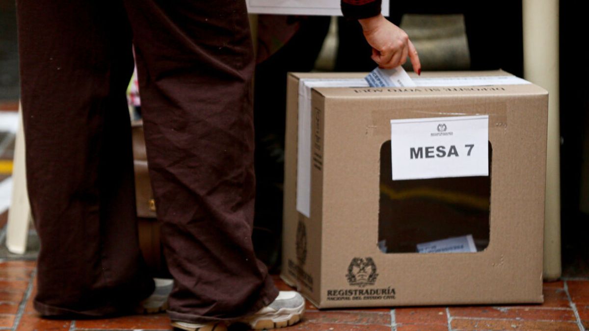 Mujer depositando su voto en la urna