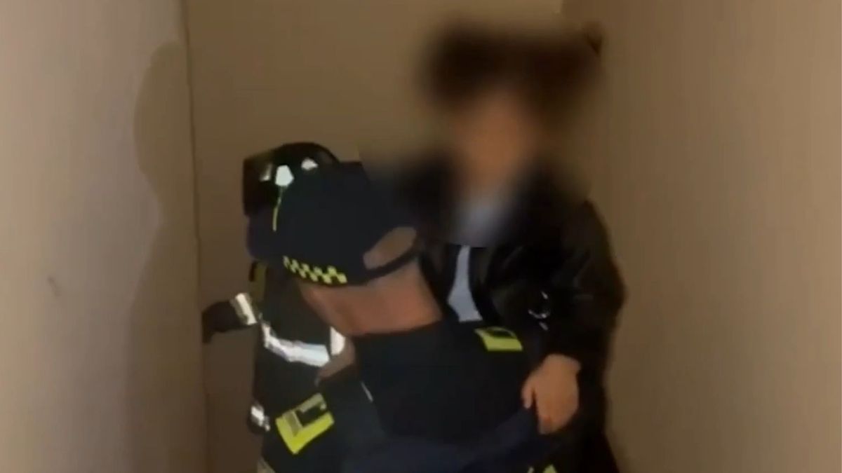 Policía cargando a menor encerrada