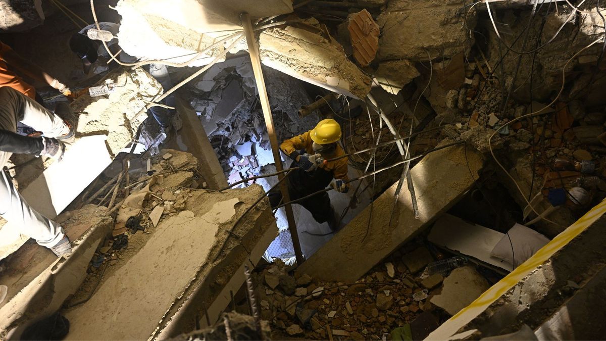 Rescatista dentro de escombros de edificio colapsado
