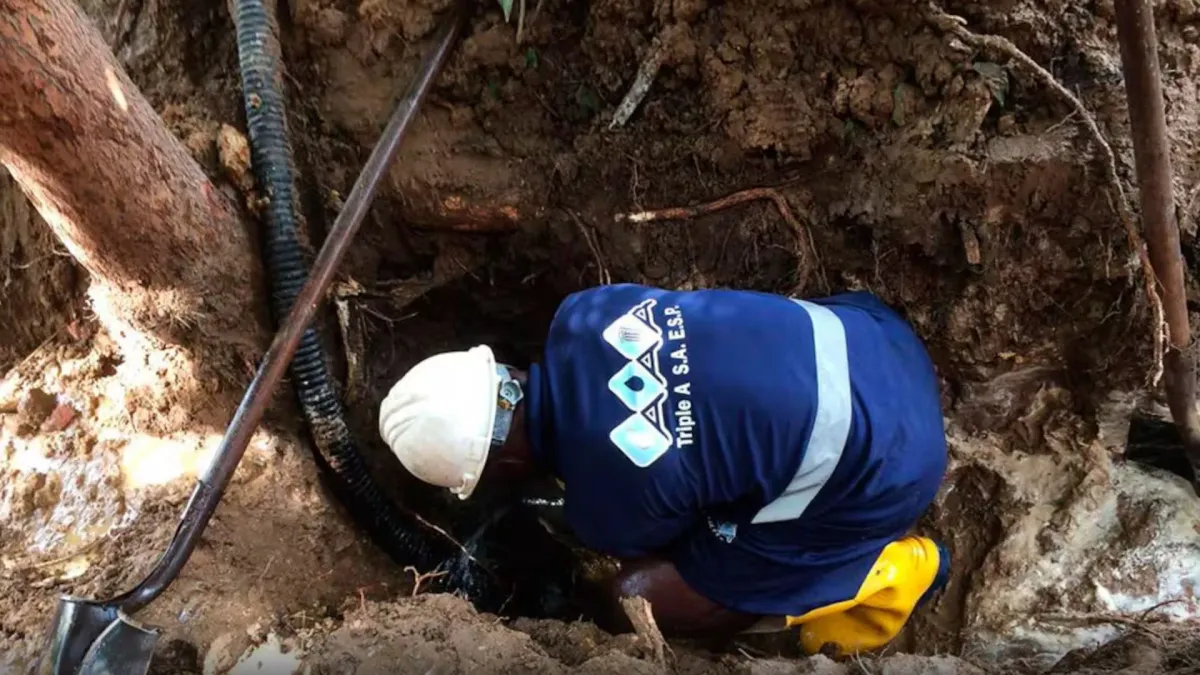 Fotografía de empleado de la empresa Triple A realizando un trabajo de mantenimiento de una tubería.