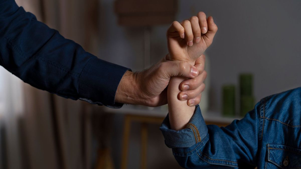 Hombre sujetando a una mujer del brazo