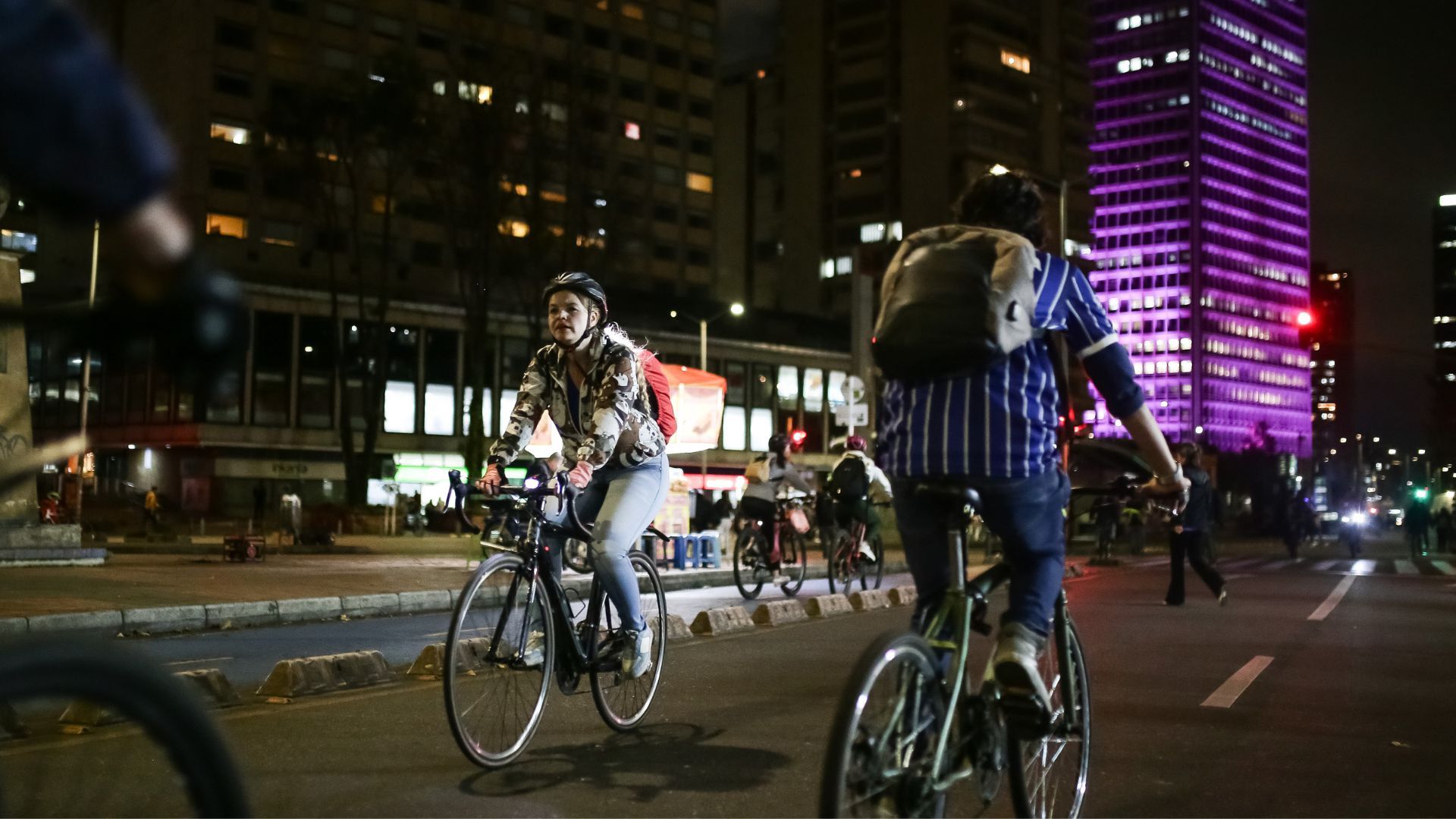 Personas recorriendo ciclovía nocturna