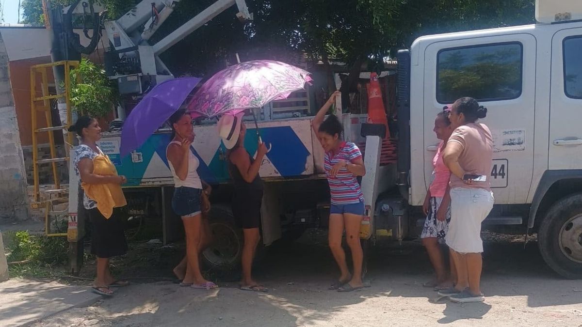 Comunidad con sombrillas mientras técnicos de Air-e realizan mantenimientos