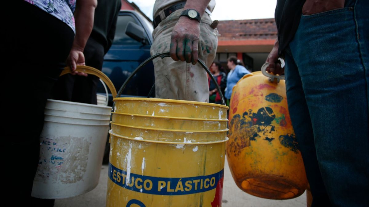 Personas con baldes para recoger agua