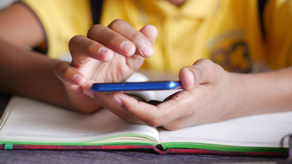 Estudiante usando celular en colegio