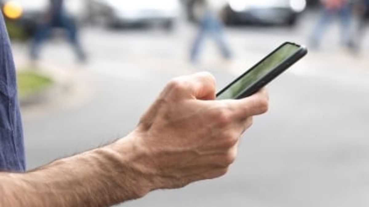 Imagen de un usuario con el celular en la calle