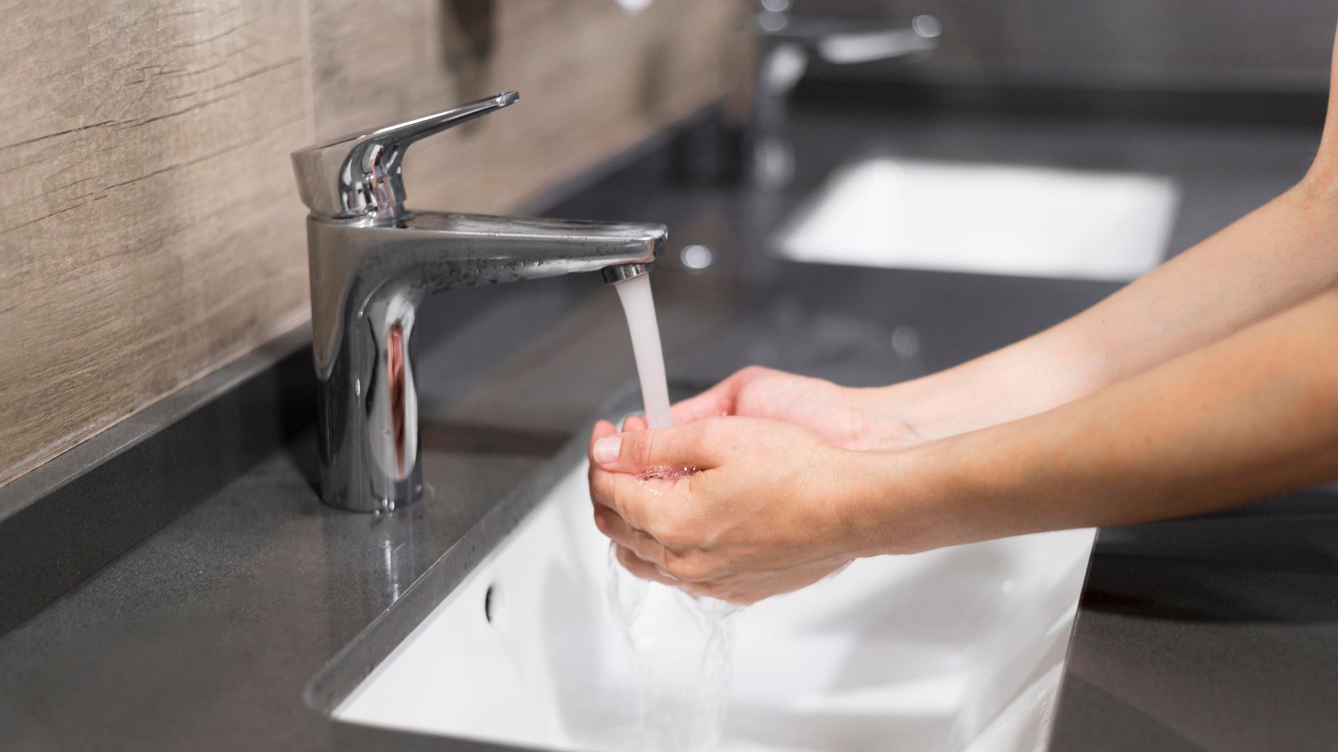 Persona lavándose las manos con agua
