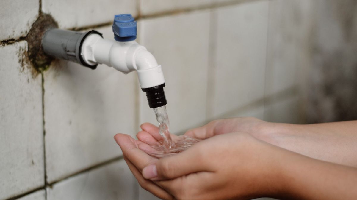 Persona lavándose las manos en la llave