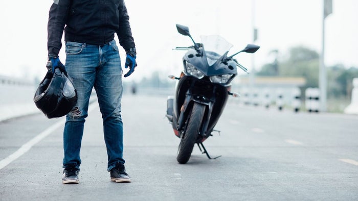 Motociclista sosteniendo el casco