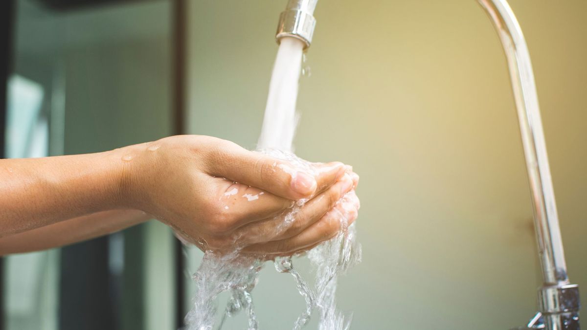 Mujer lavándose las manos con agua