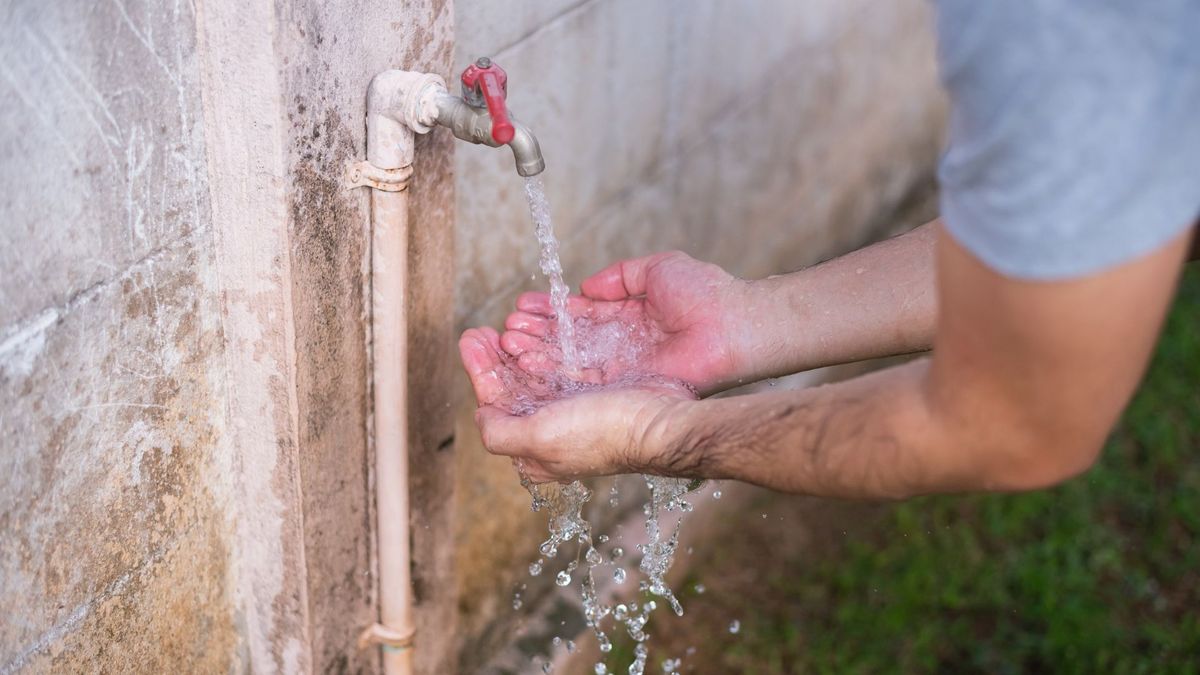 Persona lavándose las manos en una llave