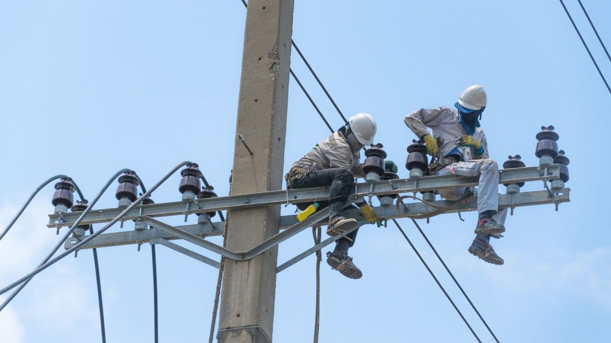 Trabajadores en poste de energía